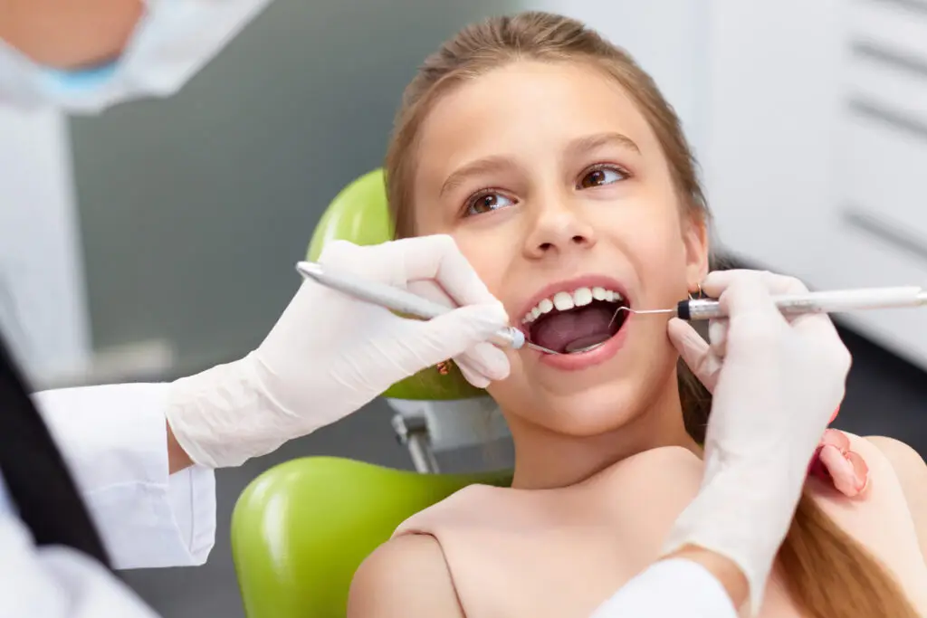 Stock image of a young girl patient having her teeth examined by the dentist